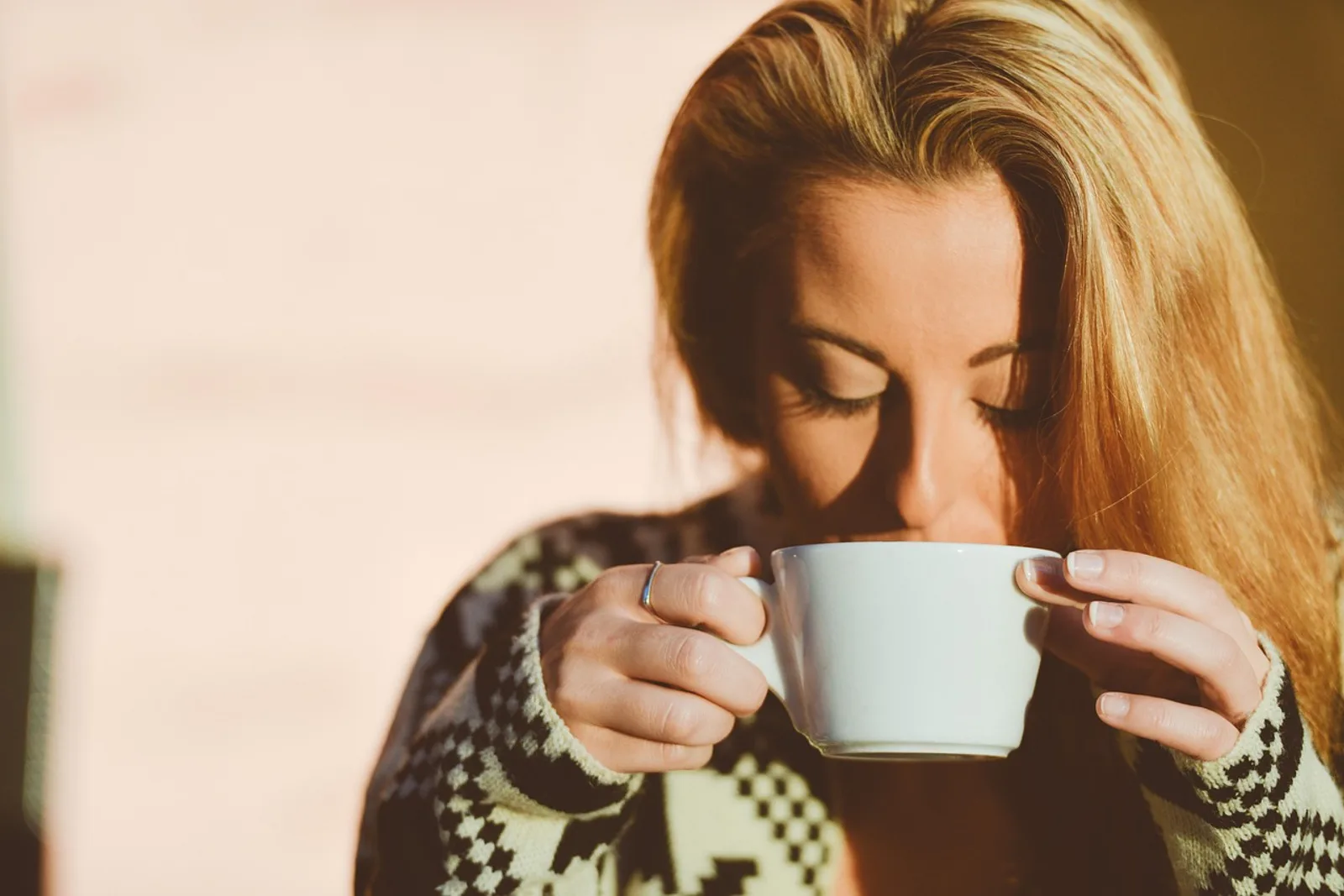 Woman sitting quietly at a kitchen table in morning light, learning how to rebuild self esteem after a breakup