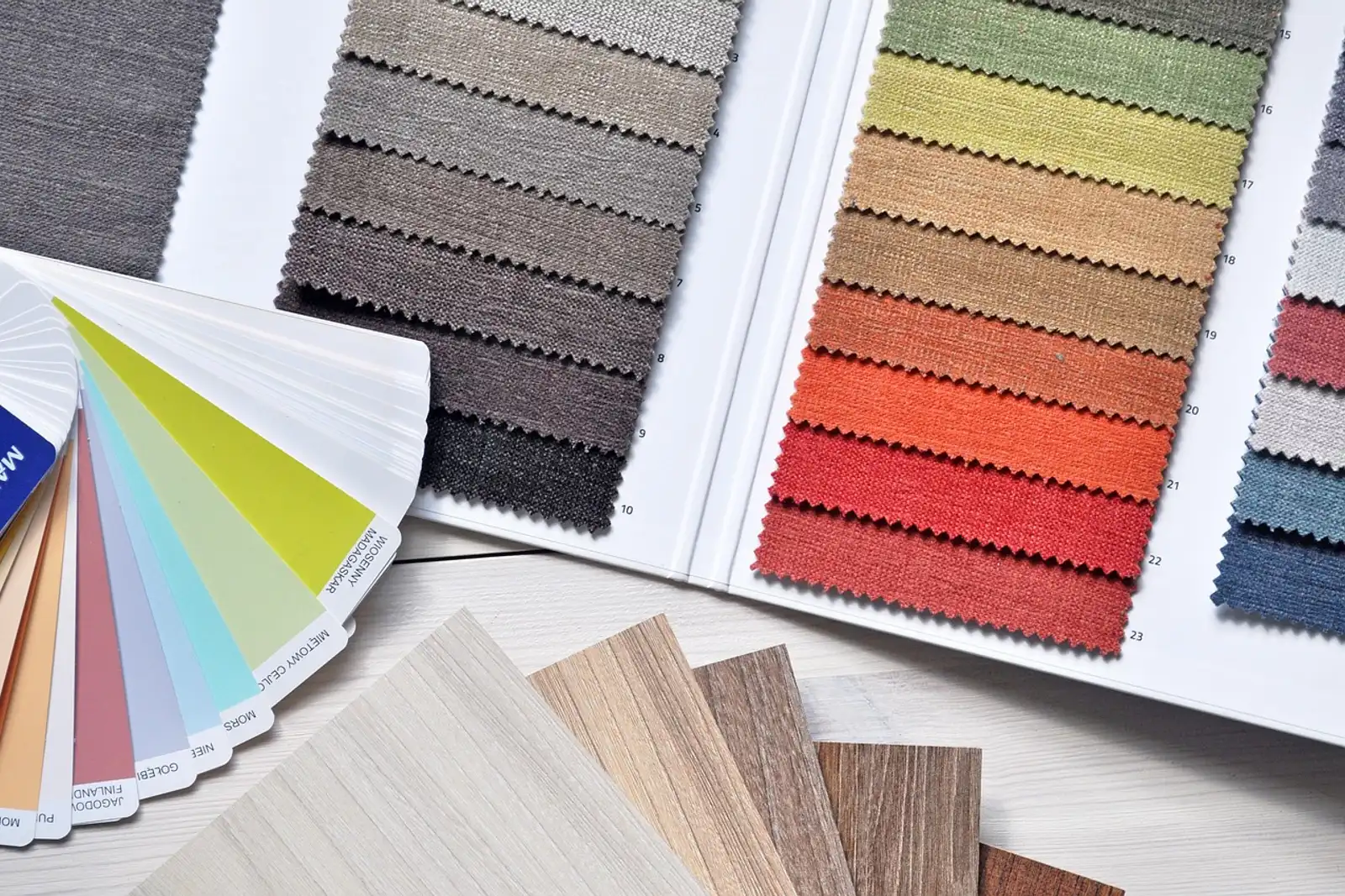 Stoffmuster, Farbfächer und Holzproben auf dem Tisch: mit einem gestalterischen Projekt beruflich neu erfinden