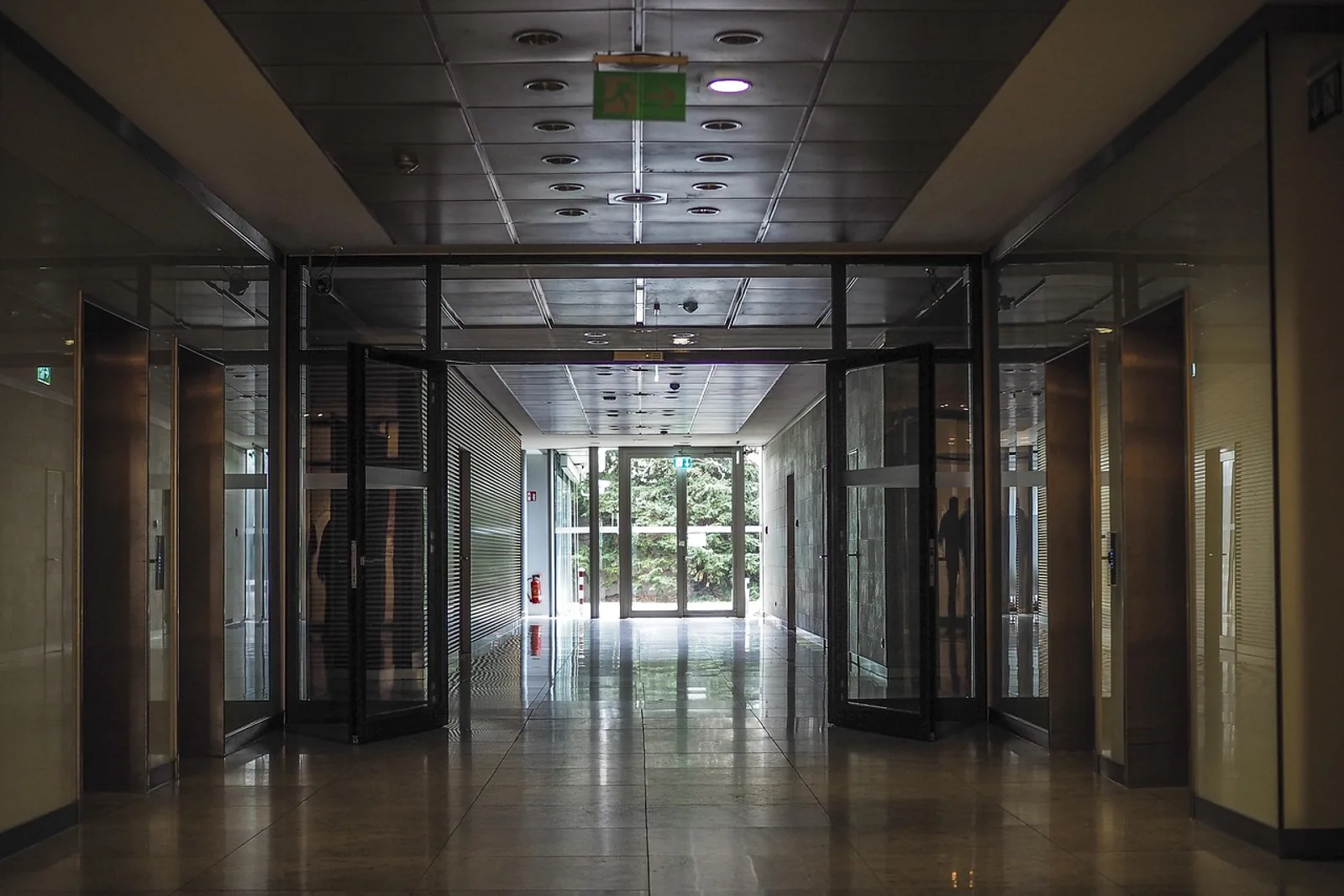 Stiller, leerer Bürogang mit offenen Glastüren vor einem Meeting – Ort der Ruhe für Hypnose für Führungskräfte