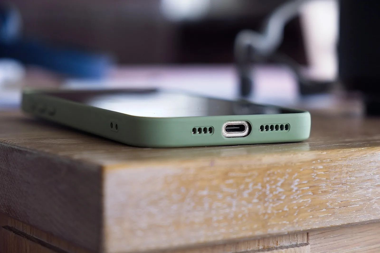 Smartphone lying face up with a dark screen on a wooden table, part of a shutdown ritual for business owners