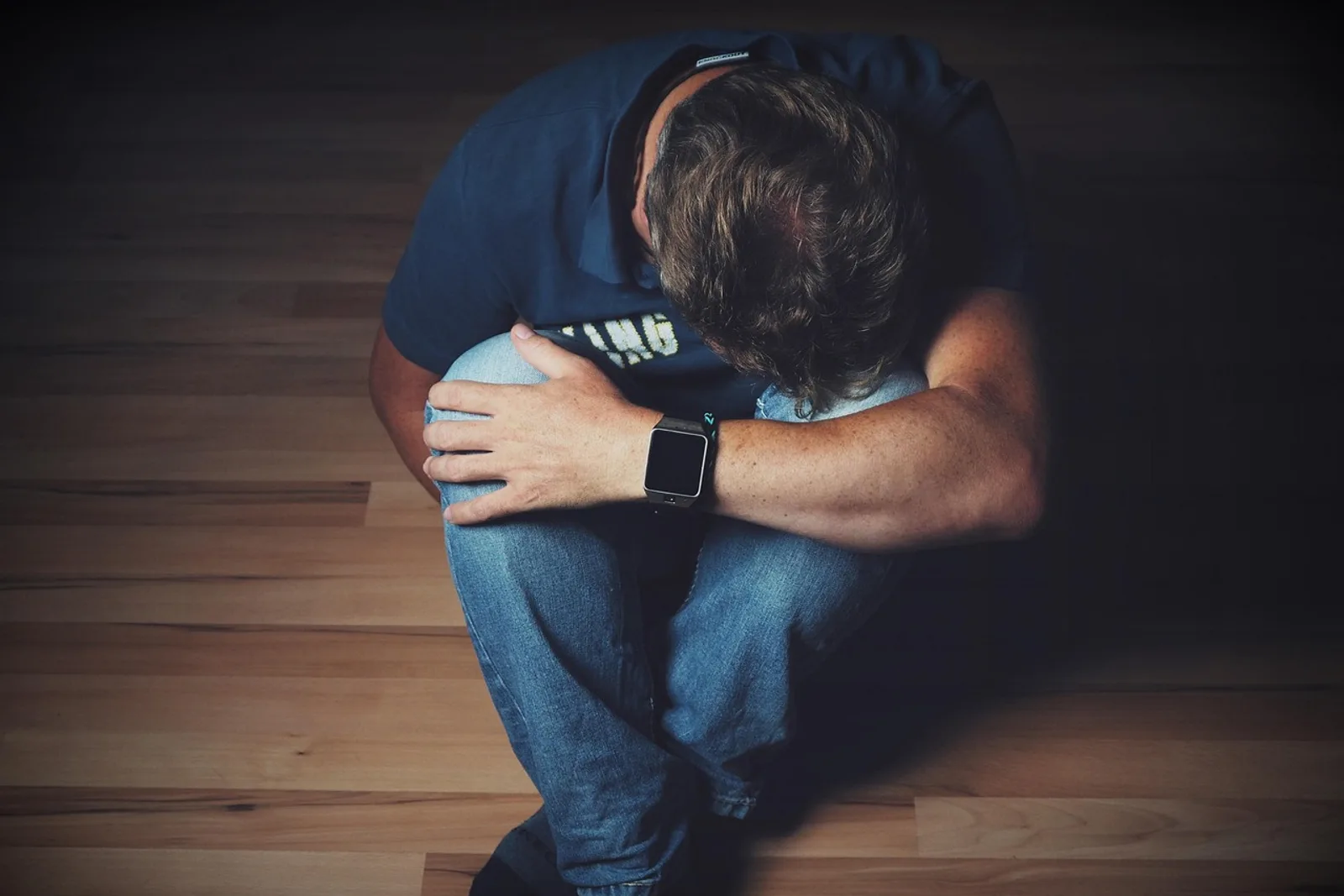 Mann sitzt mit Decke auf dem Boden neben der Heizung und schaut nach unten, Selbsthypnose-Fehler im Alltag erkennen