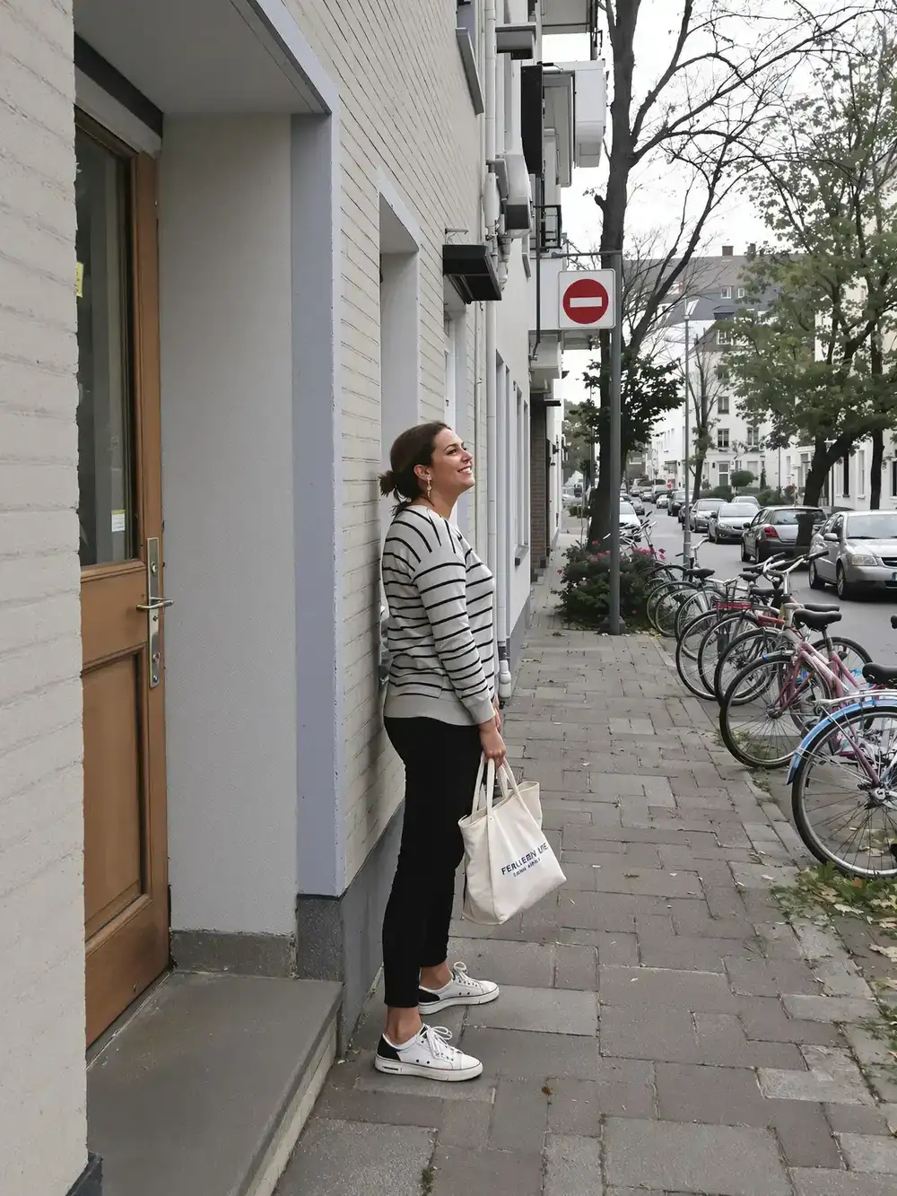 Eine Frau tritt morgens aus ihrer Haustür auf die Straße