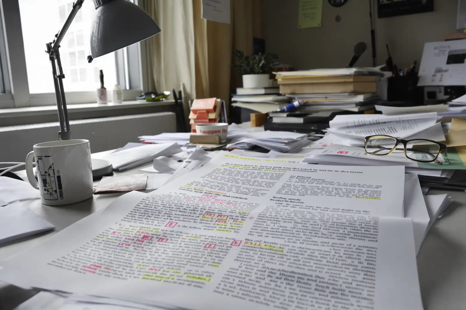 A stack of well-read scientific journals with reading glasses in the warm light of a desk lamp, the research behind Hypnaris
